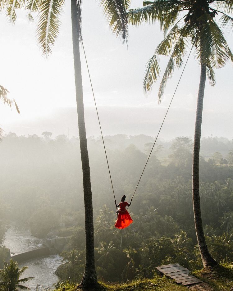 Bali swing photoshoot in a jungle valley, long gown mid-flight